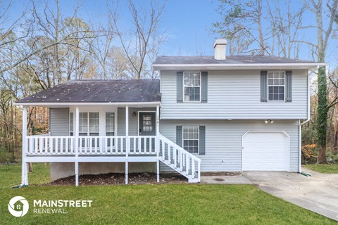 a white house with a porch and a white fence